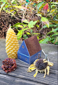 Blue matchbox house with candles and flowers on a wooden table