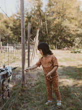 Load image into Gallery viewer, child standing outside wearing terracotta moon organic short sleeve tee and drawstring pants
