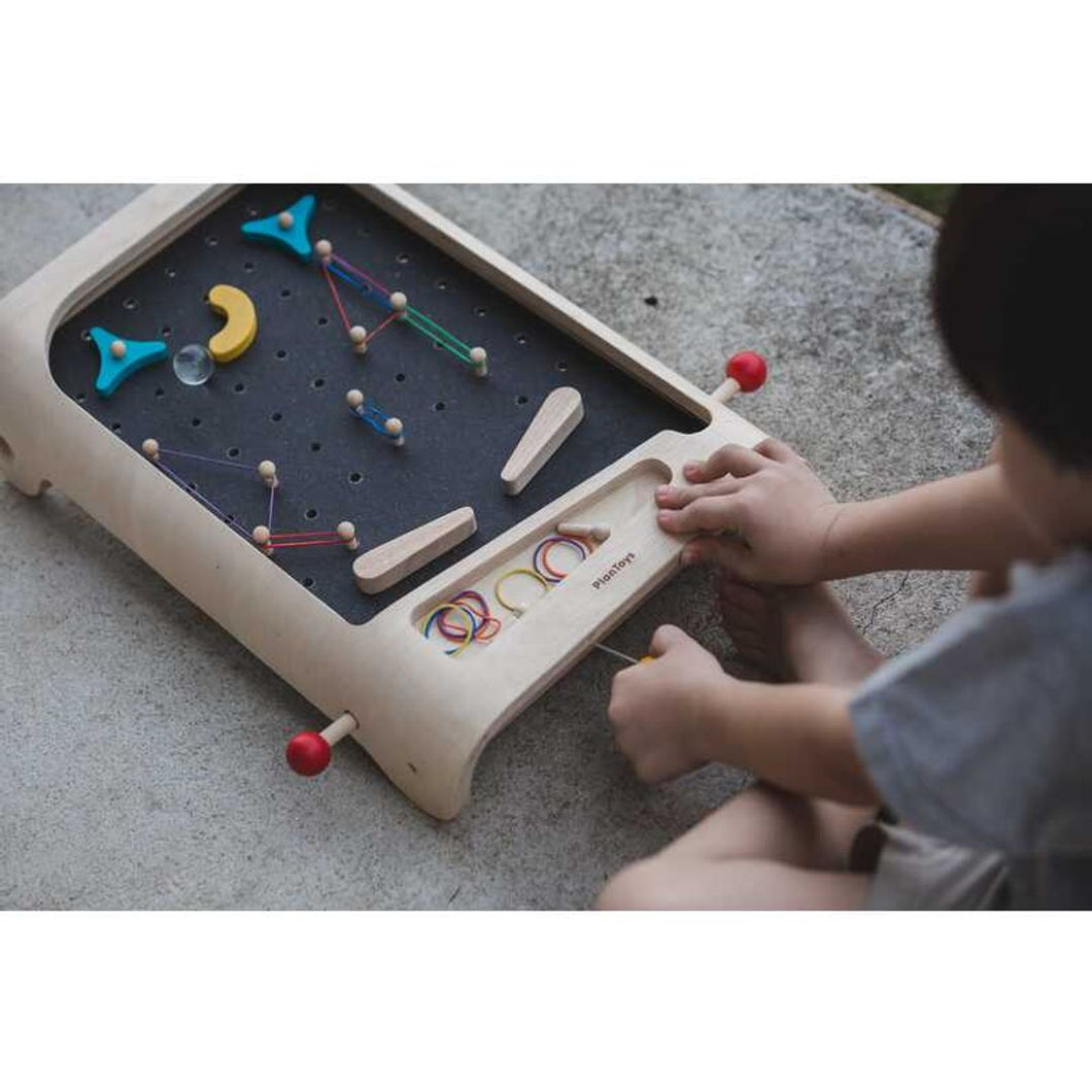 Child Playing Pinball Set by Plan Toys