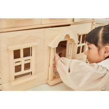 Load image into Gallery viewer, Child playing with a Victorian Dollhouse by Plan Toys
