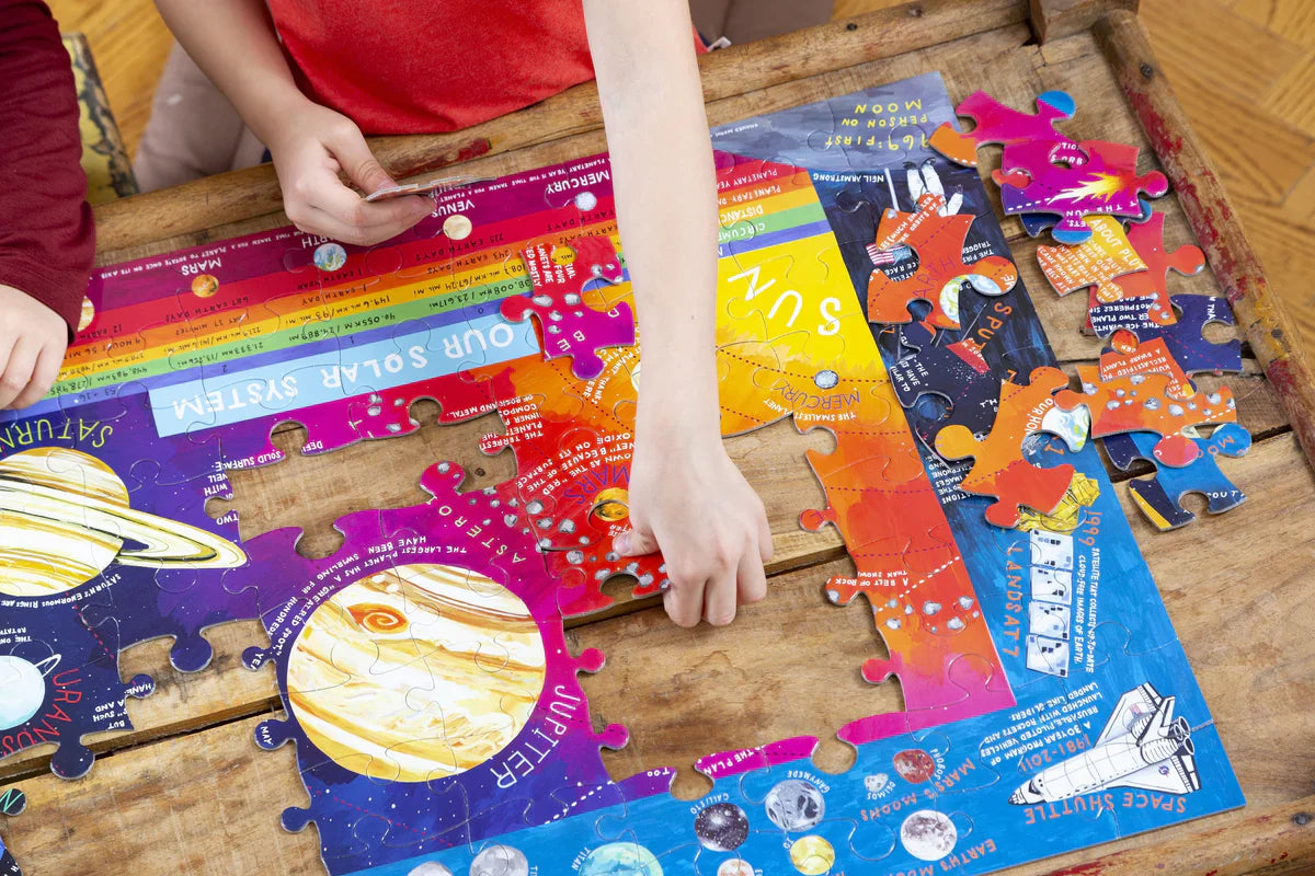 kids building a solar system puzzle on a wood table