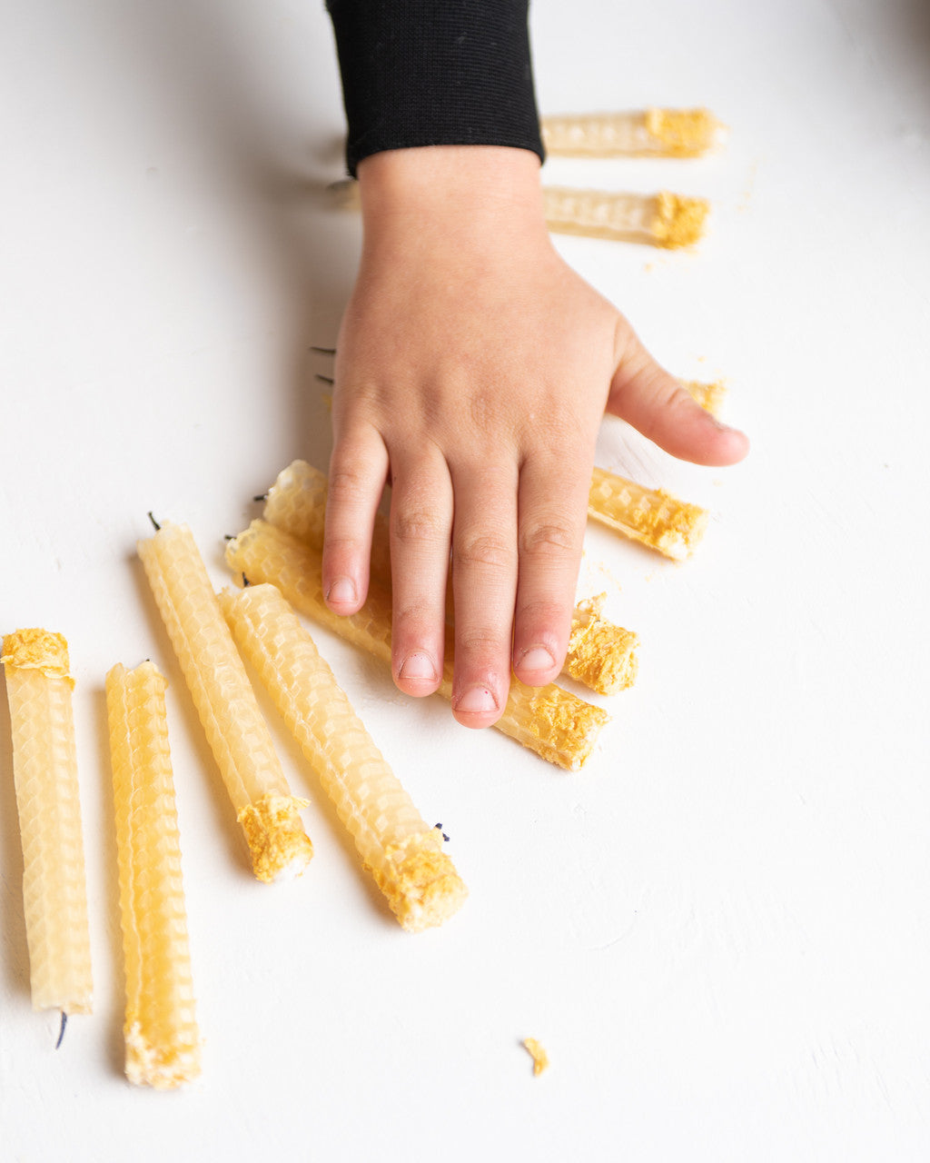 Kid making beeswax candles