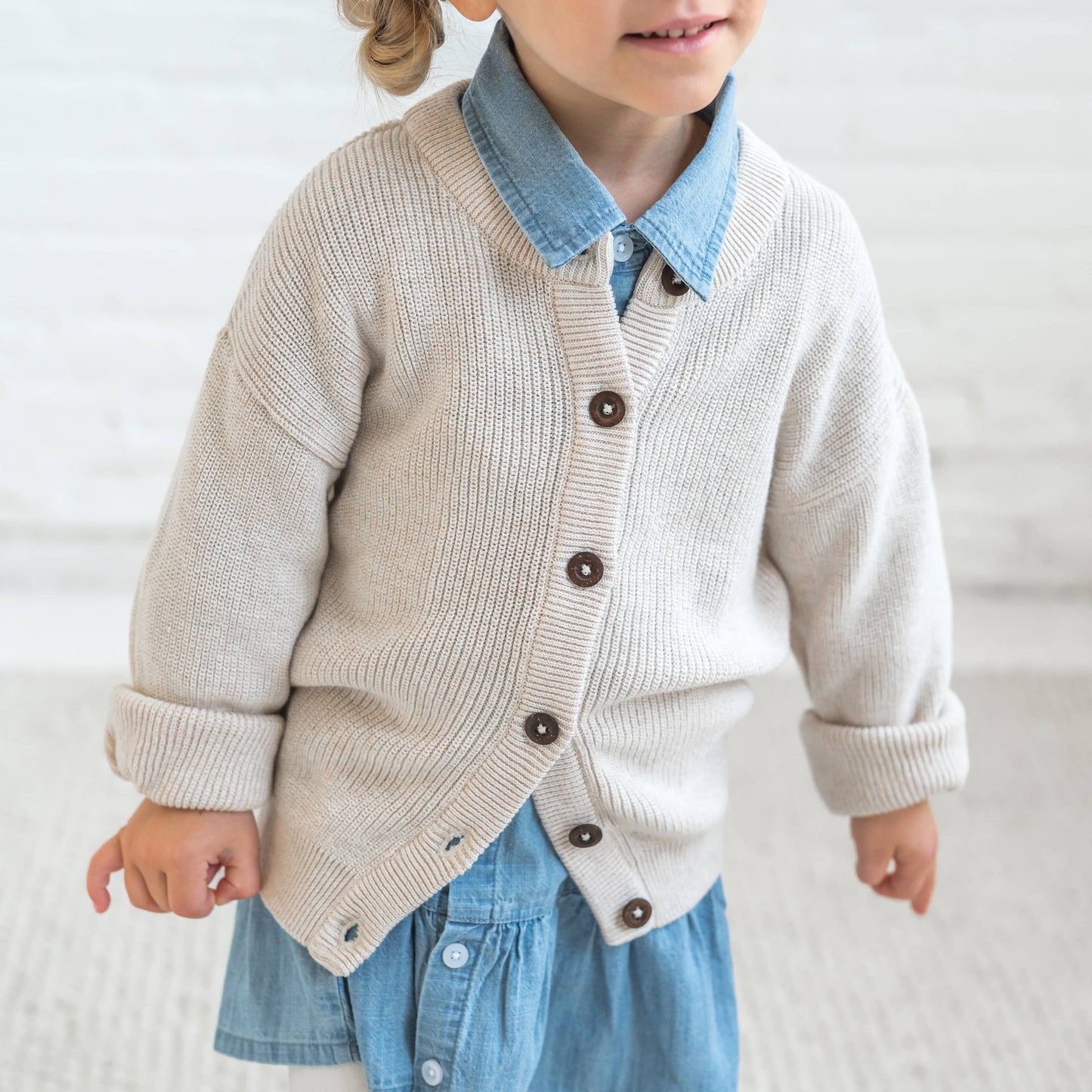 child wearing a denim dress under  heather oat knit cardigan