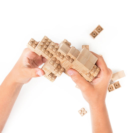 Two hands building a structure with Bamboo Eco-Bricks