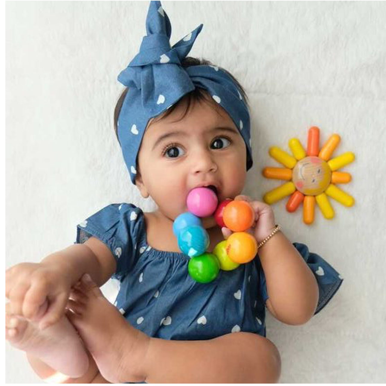 baby chewing on a magica teether by haba