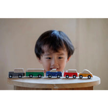 Load image into Gallery viewer, child playing with the Vehicles by Plan Toys

