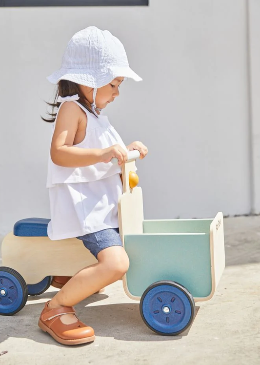 Kind riding the plan toys orchard delivery bike