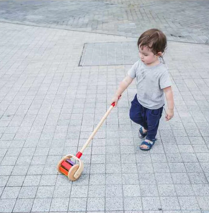 Child playing with the Walk 'n Roll Rainbow by plan toys