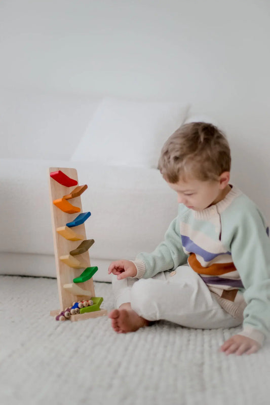 a child sitting on the floor playing with color zigzag racing car