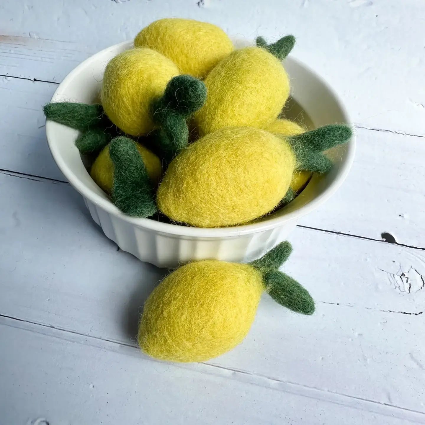 a bowl of felt lemons