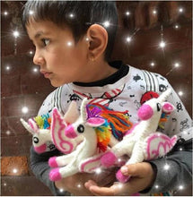 Load image into Gallery viewer, child holding three small felt rainbow unicorns
